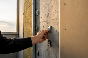 Hand fitting isolation clips on concrete wall