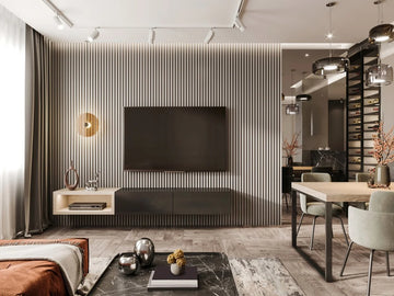 Modern living room with a television mounted on a striped wall, a coffee table with decorative items, and a dining area.