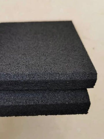 Two pieces of black foam rubber on a beige surface